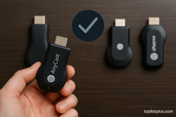 มือกำลังถืออุปกรณ์ Anycast ขณะที่อุปกรณ์อื่น ๆ วางอยู่ด้านหลังบนโต๊ะไม้ พร้อมแสดงภาพเปรียบเทียบเพื่อประกอบการตัดสินใจว่า Anycast รุ่นไหนดี