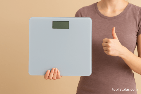 รูปภาพประกอบบทความ เคล็ดลับการเลือกซื้อเครื่องชั่งน้ำหนัก ยี่ห้อไหนดี แสดงผู้หญิงถือเครื่องชั่งน้ำหนักดิจิทัล