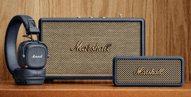 ผู้ใช้งานกำลังค้นหา "ลําโพง Marshall รุ่นไหนดี" ผ่านสมาร์ตโฟน โดยมีลําโพง Marshall ตั้งอยู่บนโต๊ะ