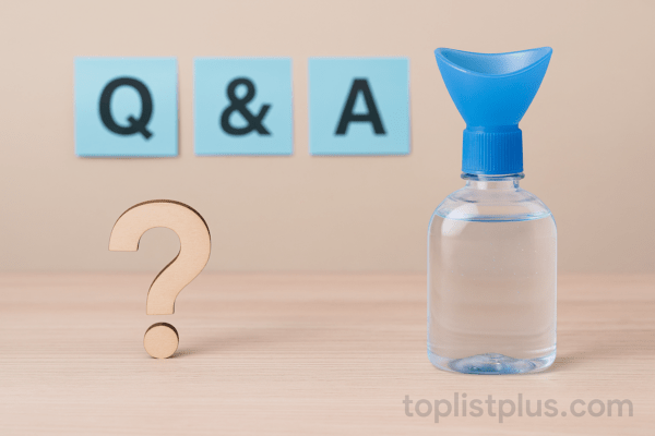 ขวดน้ำยาล้างตาพร้อมฝาสีน้ำเงินวางบนโต๊ะไม้ ข้างๆ มีสัญลักษณ์เครื่องหมายคำถาม ใช้ประกอบหัวข้อคำถามที่พบบ่อยในบทความ "น้ำยาล้างตา ยี่ห้อไหนดี"