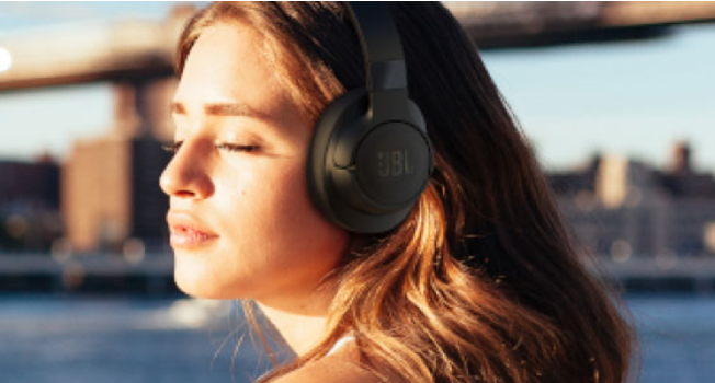 หูฟังบลูทูธ JBL รุ่นไหนดี พร้อมเคสชาร์จสีกรมวางบนโต๊ะไม้ สำหรับประกอบบทความ SEO เคล็ดลับการเลือกซื้อ