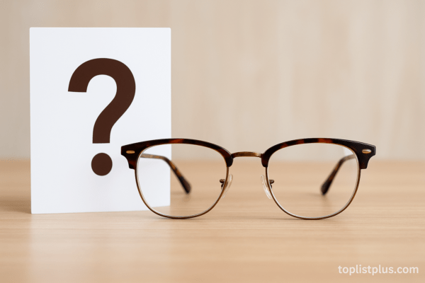 กรอบแว่นสายตา ยี่ห้อไหนดี วางอยู่บนโต๊ะไม้ พร้อมสัญลักษณ์คำถามข้างๆ