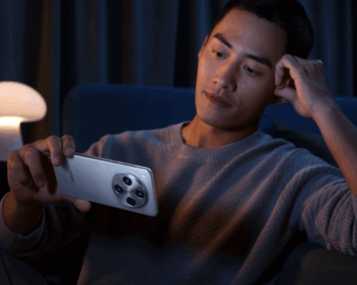 ชายหนุ่มกำลังดูวิดีโอหรือใช้งานสมาร์ทโฟน OPPO สีเงินในแนวนอน แสดงให้เห็นถึงดีไซน์ที่สวยงามและกล้องที่โดดเด่น ซึ่งเป็นส่วนหนึ่งของ 5 เหตุผลที่คนเลือก OPPO มากกว่าแบรนด์อื่น