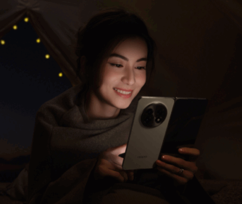 ผู้หญิงกำลังใช้สมาร์ทโฟนจอพับ OPPO ในที่มืด เน้นการใช้งานจอแสดงผลและคุณภาพกล้องที่ต้องพิจารณาใน วิธีดูสเปกมือถือ OPPO ก่อนซื้อ