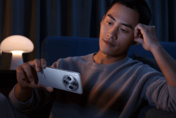ชายหนุ่มกำลังนั่งดูวิดีโอหรือเล่นเกมบนสมาร์ทโฟน OPPO รุ่นไหนเหมาะกับนักเรียน / นักศึกษา สีเงินในแนวนอน ซึ่งแสดงให้เห็นถึงความบันเทิงที่ตอบโจทย์ชีวิตนักศึกษาได้