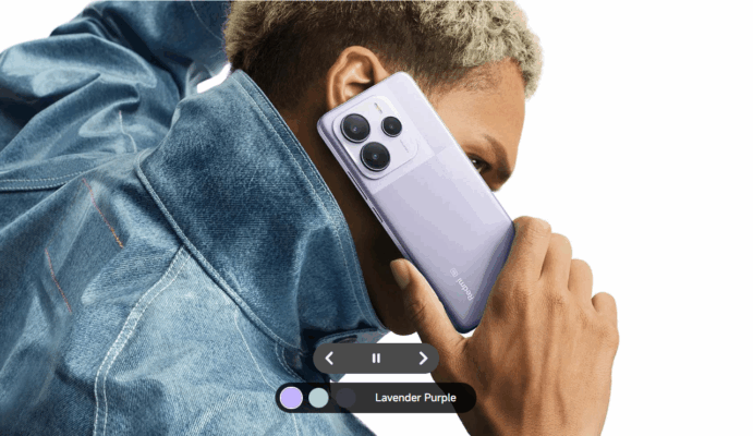 ชายสวมเสื้อยีนส์กำลังถือสมาร์ทโฟน Redmi Note 14 5G สี Lavender Purple แนบหู เน้นดีไซน์และสีสันของเครื่องในการ รีวิว Redmi Note 14 5G