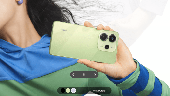 โทรศัพท์มือถือ Redmi สีเขียวอ่อน (Mist Purple) ถูกชูขึ้นโดยนางแบบที่สวมเสื้อผ้าสีน้ำเงิน-เขียว โดยเน้นที่ดีไซน์ฝาหลัง โมดูลกล้องหลัง และการแสดงสีสันของรุ่น ภาพนี้แสดงถึงตัวเลือกสีและดีไซน์ของ Redmi ที่นำมาเปรียบเทียบในบทความ TECNO vs Redmi