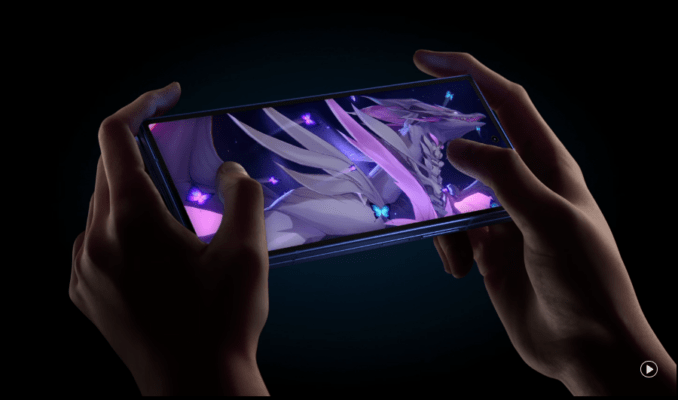 Samsung Galaxy Z Fold 7 vs Honor Magic V5 - ภาพมือถือพับได้กำลังถูกจับโดยสองมือในสภาพแสงน้อย หน้าจอแสดงผลกราฟิกเกมรูปมังกรสีม่วง-ขาวที่สวยงาม พร้อมเอฟเฟกต์ผีเสื้อสีม่วง ซึ่งสื่อถึงประสบการณ์การเล่นเกมอันทรงพลังบนสมาร์ทโฟน